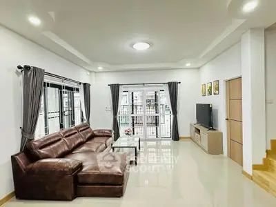 Spacious modern living room with leather sofa and large windows