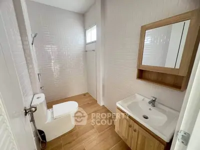 Modern bathroom with wooden accents and sleek white tiles
