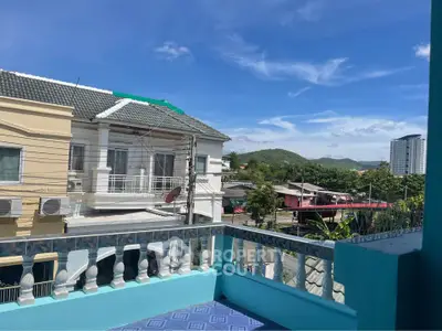 Charming balcony view with scenic landscape and modern architecture under clear blue skies.