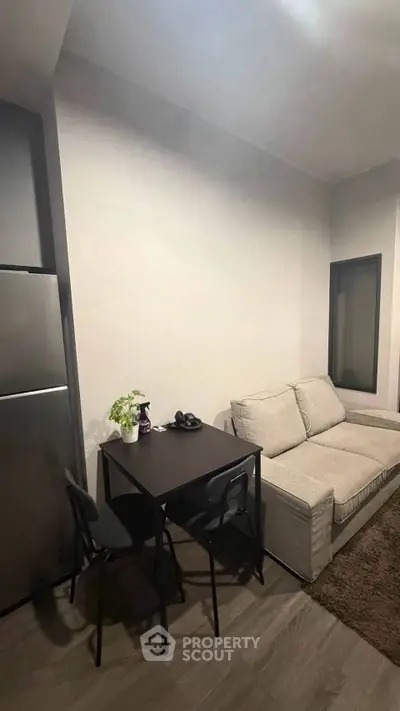 Cozy living room with modern sofa and dining table, perfect for small apartments.