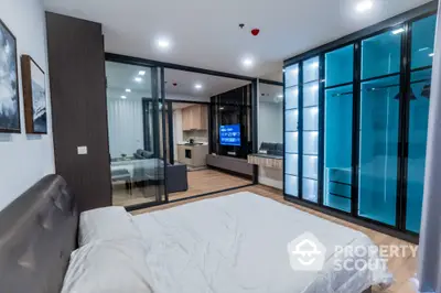 Modern bedroom with glass wardrobe and open view to living area