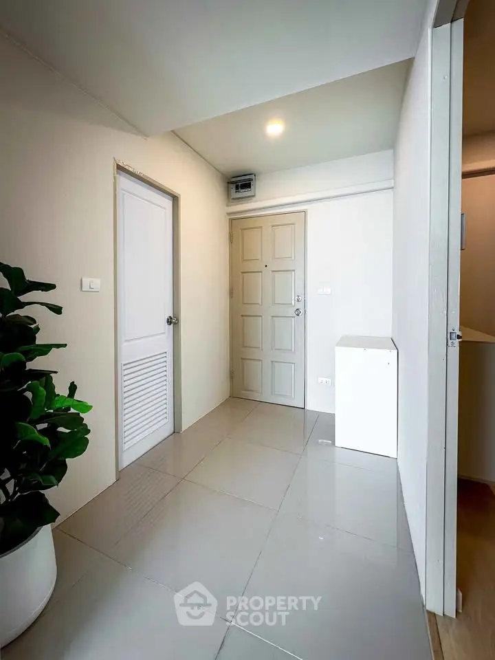 Modern apartment entrance with sleek tile flooring and neutral walls