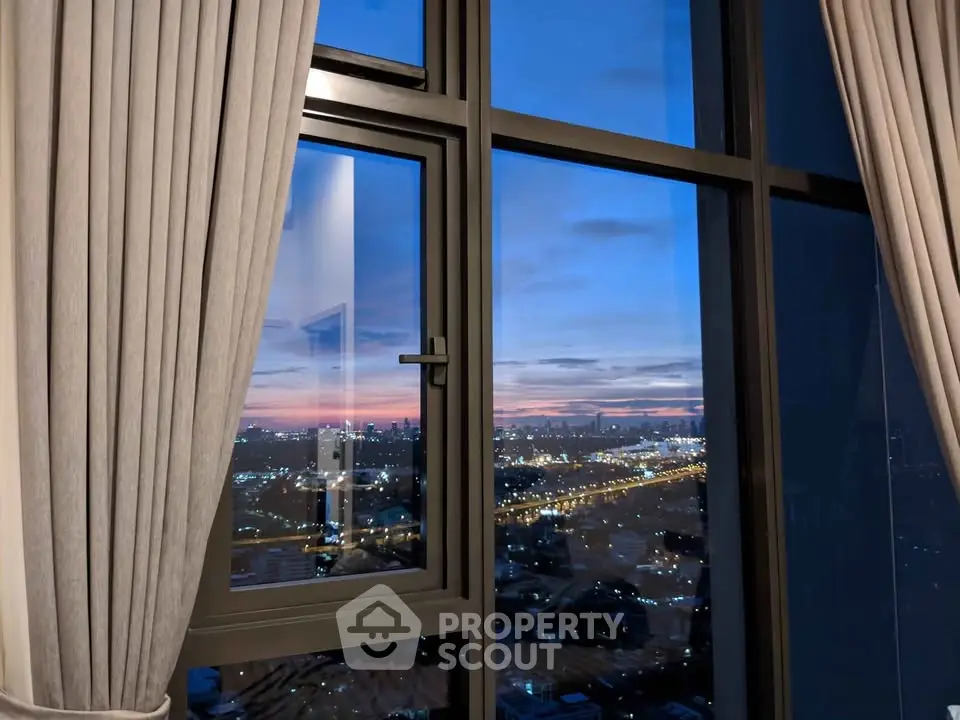 Stunning cityscape view from high-rise apartment window at sunset.