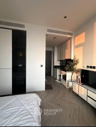 Modern studio apartment with sleek kitchen and cozy bedroom area