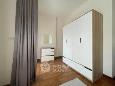 Modern bedroom with sleek wardrobe and wooden flooring