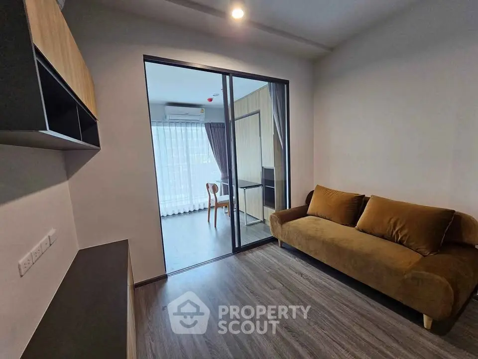 Modern living room with brown sofa and sliding glass door to balcony
