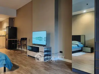 Modern studio apartment with open layout, featuring a cozy living area and sleek kitchen.