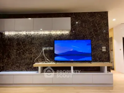 Modern living room with sleek TV setup and elegant marble wall design