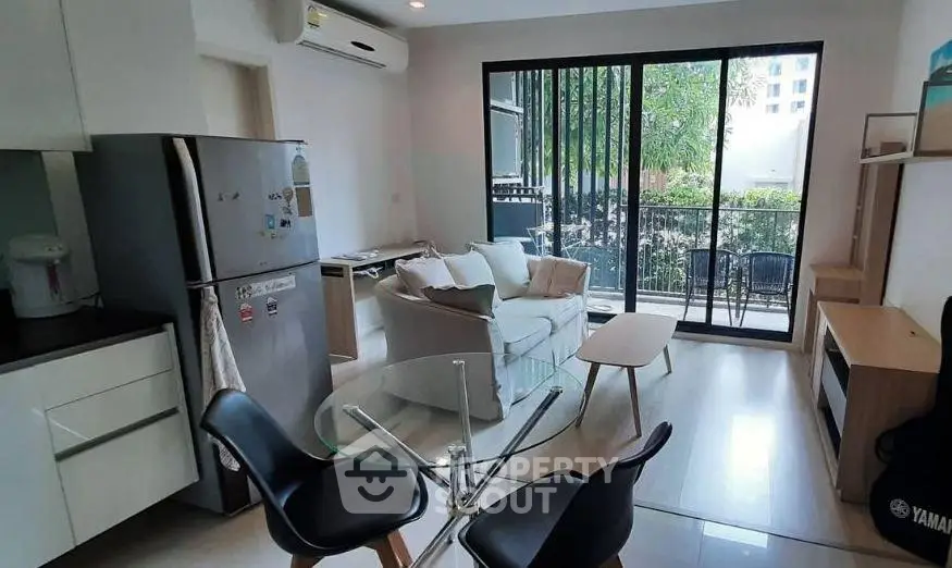 Modern living room with glass table and balcony view in stylish apartment