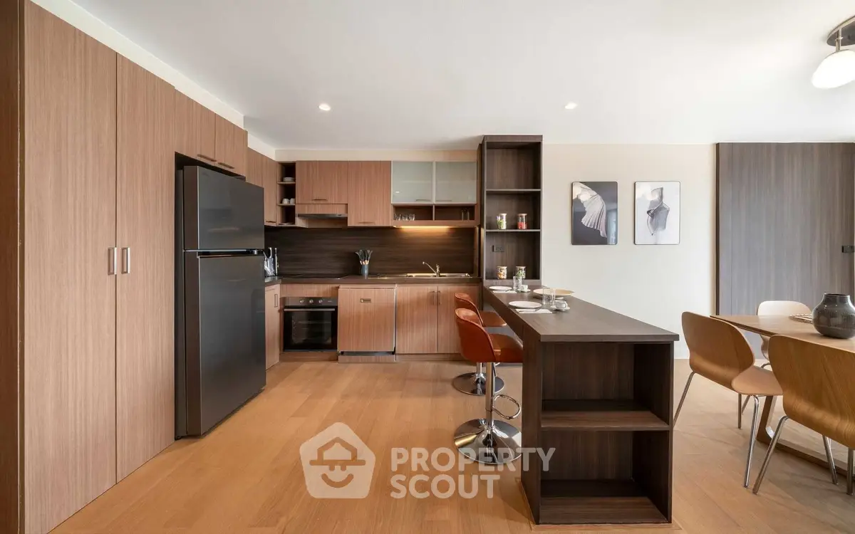 Modern kitchen with open layout and stylish dining area in contemporary apartment.