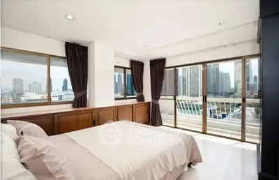 Spacious bedroom with city view and large windows in modern apartment