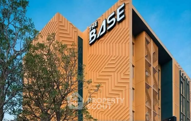 Modern architectural building with unique geometric facade and lush greenery.