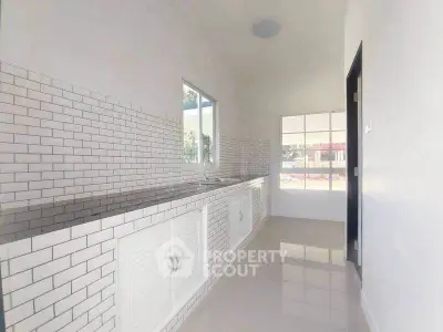 Sleek modern kitchen with white subway tiles and ample natural light.