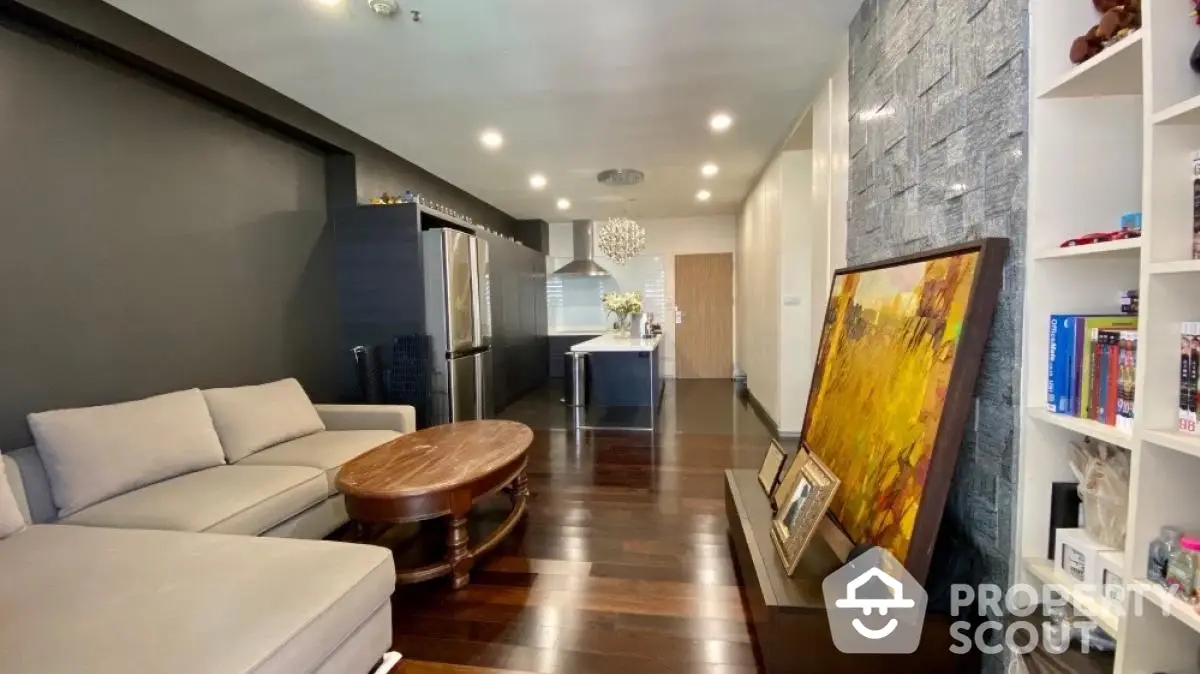 Modern living room with open kitchen, dark wood floors, and stylish decor