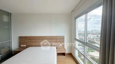 Bright bedroom with large windows offering stunning city views in modern apartment.