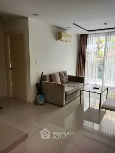 Cozy living room with modern sofa and large window offering natural light