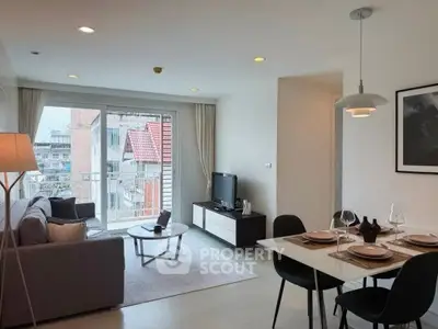 Modern living room with dining area and city view, featuring sleek furniture and contemporary decor.