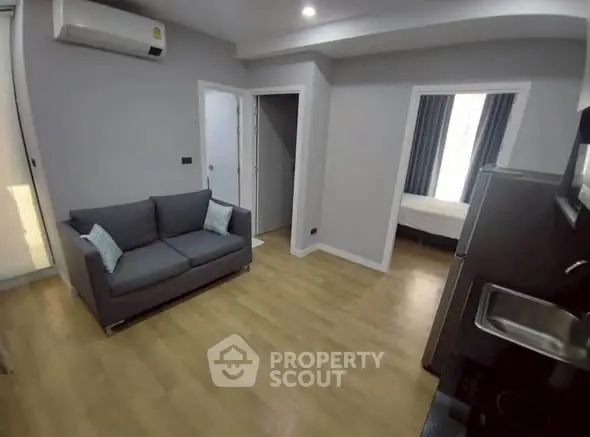Modern apartment interior with cozy living room and visible bedroom