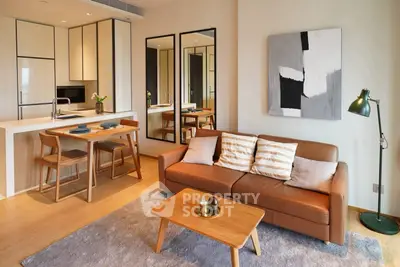 Modern living room with open kitchen, stylish furniture, and contemporary decor.