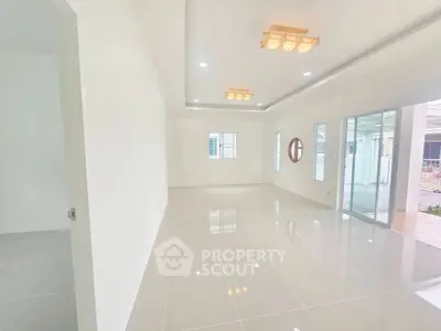 Spacious modern living room with glossy tile flooring and large windows.