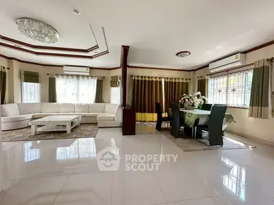 Spacious living room with elegant dining area, featuring large windows and modern furnishings.