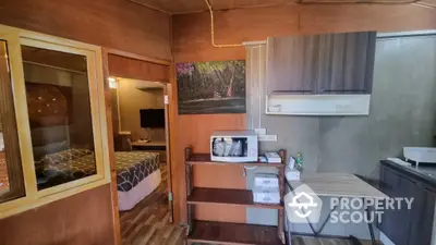 Cozy studio apartment with wooden interiors, modern appliances, and efficient space utilization, perfect for singles or couples.