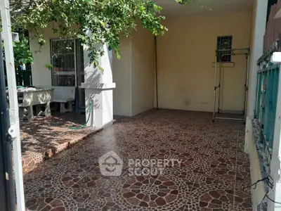 Charming outdoor patio with decorative tile flooring and lush greenery