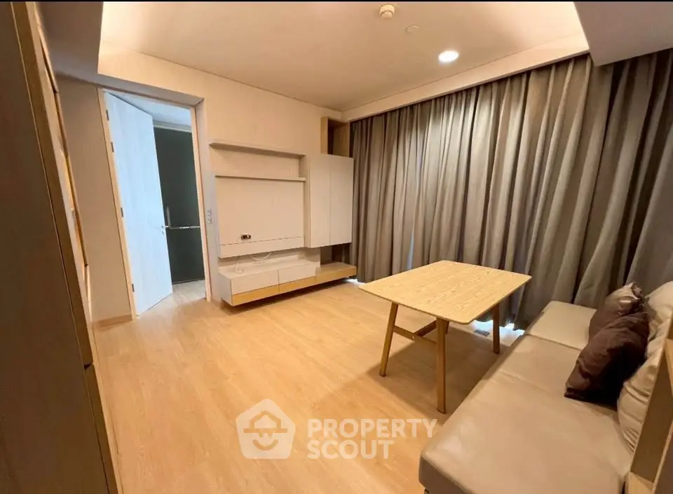 Modern living room with wooden flooring, cozy sofa, and elegant curtains in a stylish apartment.