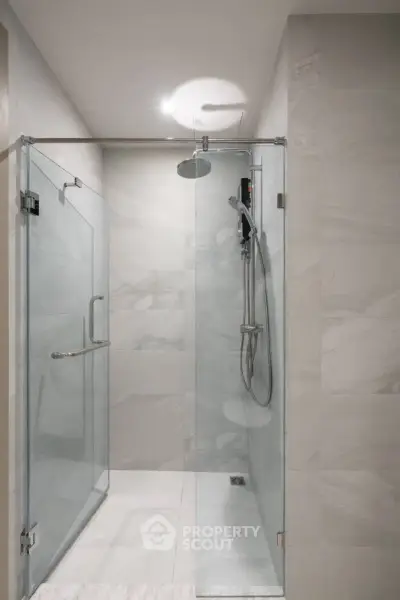Modern bathroom with sleek glass shower enclosure and contemporary fixtures.