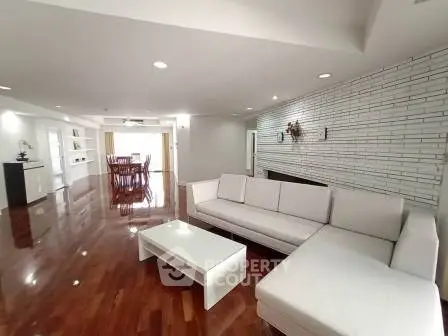 Spacious modern living room with sleek white furniture and polished wooden floors.