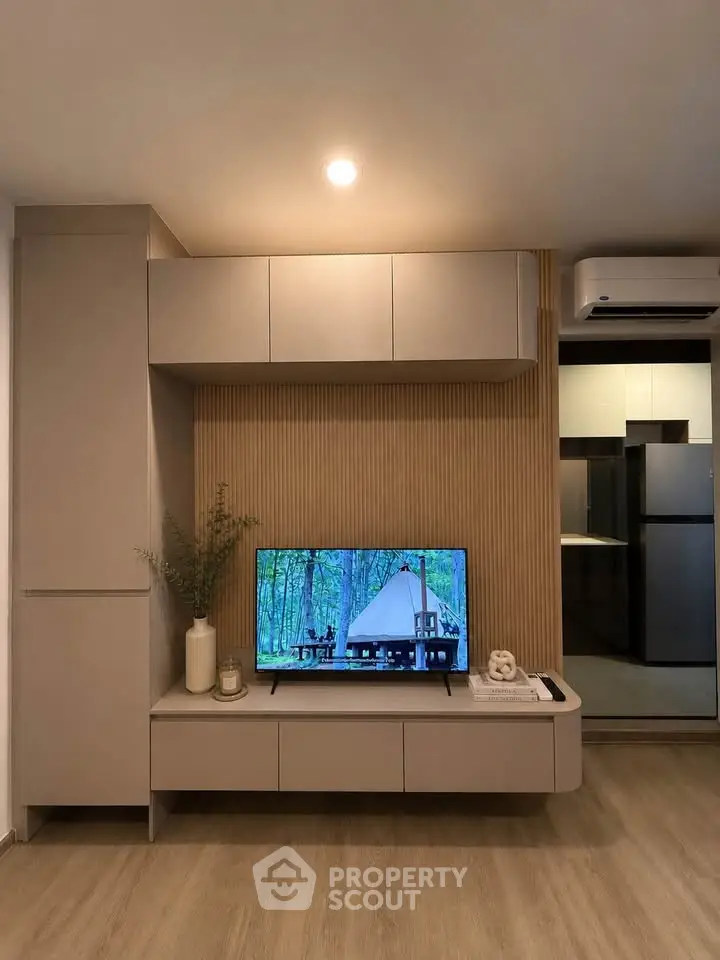 Modern living room with sleek TV unit and stylish decor, featuring a cozy ambiance and contemporary design.