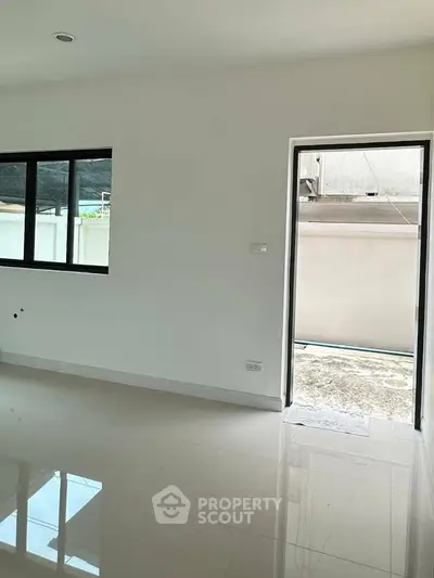 Spacious modern room with glossy tiled floor and large windows, perfect for natural light.