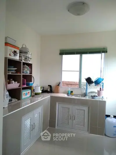 Charming kitchen with ample storage and natural light, featuring a closed layout and modern appliances.