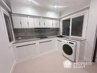 Modern kitchen with sleek cabinetry and built-in washing machine