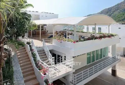 Stunning modern building with spacious terrace and lush greenery, perfect for luxury living.