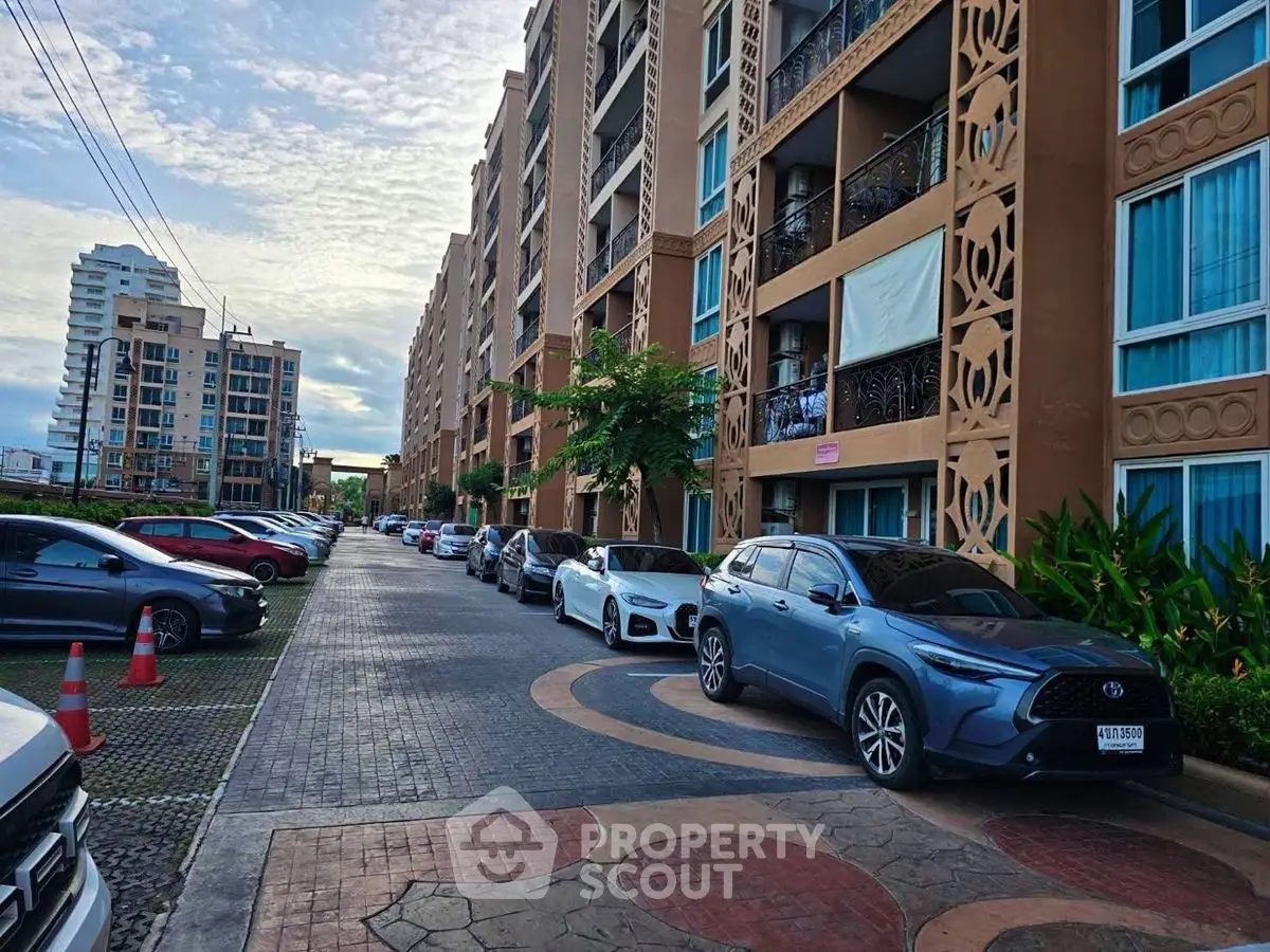 Modern apartment complex with parked cars and intricate facade design.