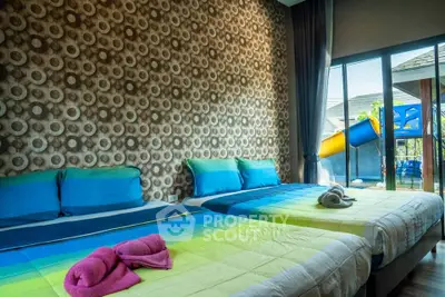 Modern bedroom with two beds and vibrant decor, featuring large windows and outdoor view.