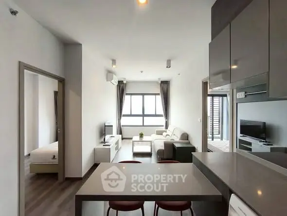 Modern open-plan living room with sleek kitchen and cozy seating area