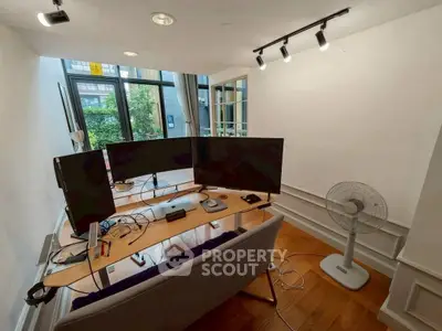 Modern home office with dual monitors and garden view, perfect for productivity.