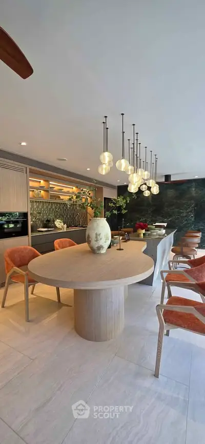 Luxurious open-plan kitchen and dining area with modern lighting and elegant decor.