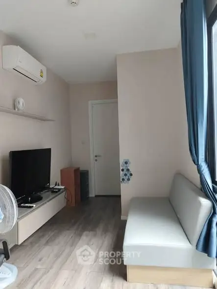 Modern living room with sleek furniture and large window for natural light.