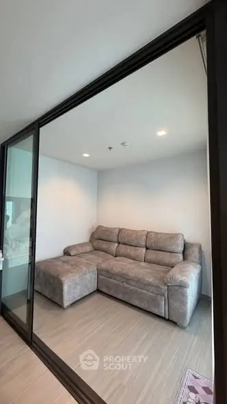 Modern living room with stylish gray sectional sofa and glass sliding doors