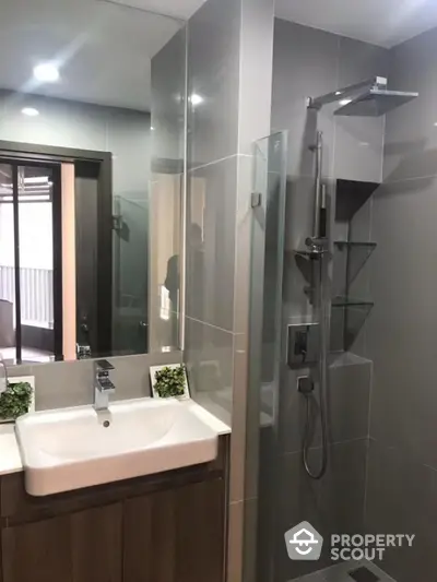 Modern bathroom with sleek shower and stylish vanity in contemporary apartment.