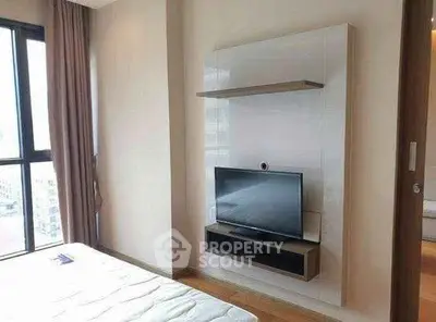 Modern bedroom with wall-mounted TV and large window offering city views.