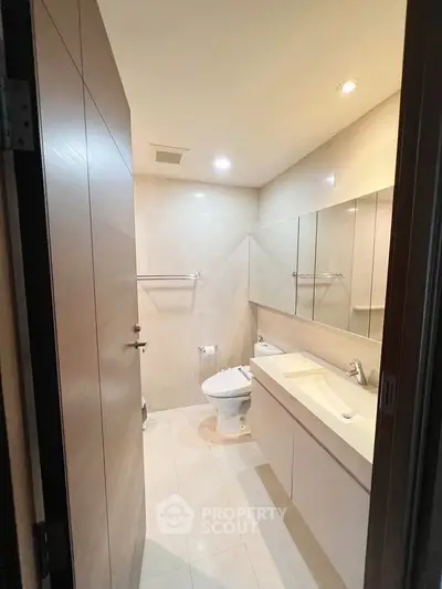 Modern bathroom with sleek fixtures and ample lighting in a contemporary apartment.