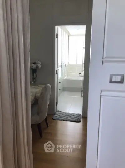 Elegant interior view with a glimpse of a modern bathroom and cozy dining area.