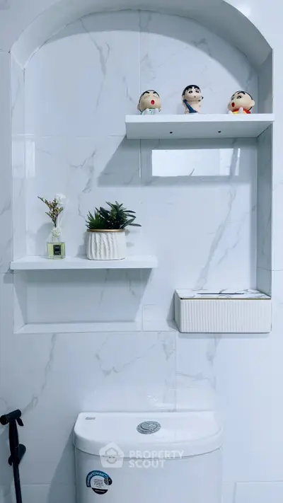 Modern bathroom with marble tiles and decorative shelves