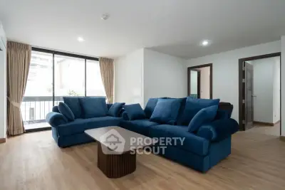 Spacious living room with modern blue sofas and large window view