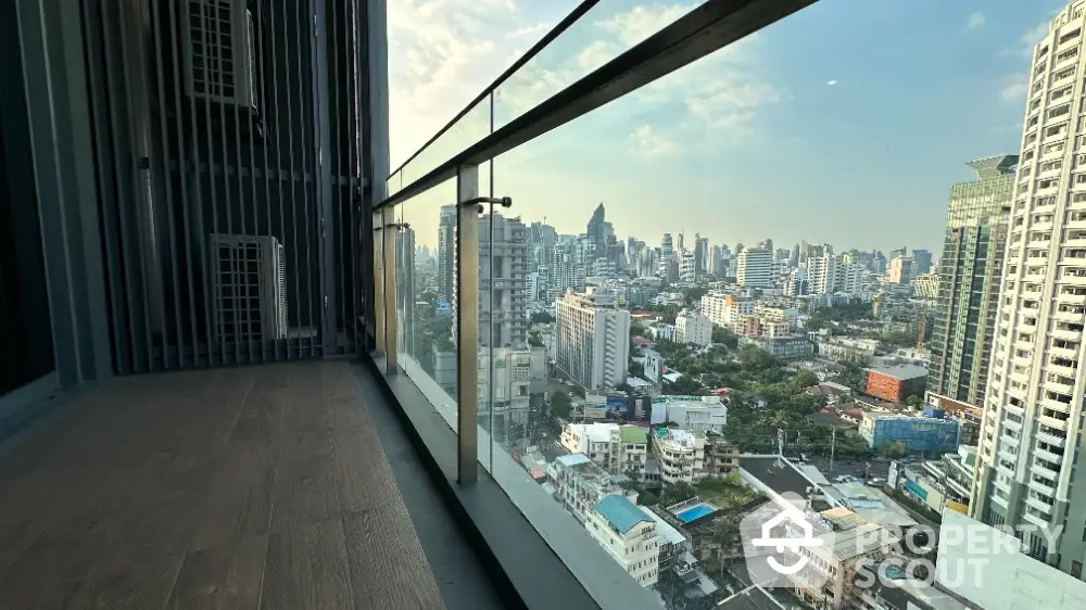 Stunning high-rise balcony view of city skyline with modern glass railing