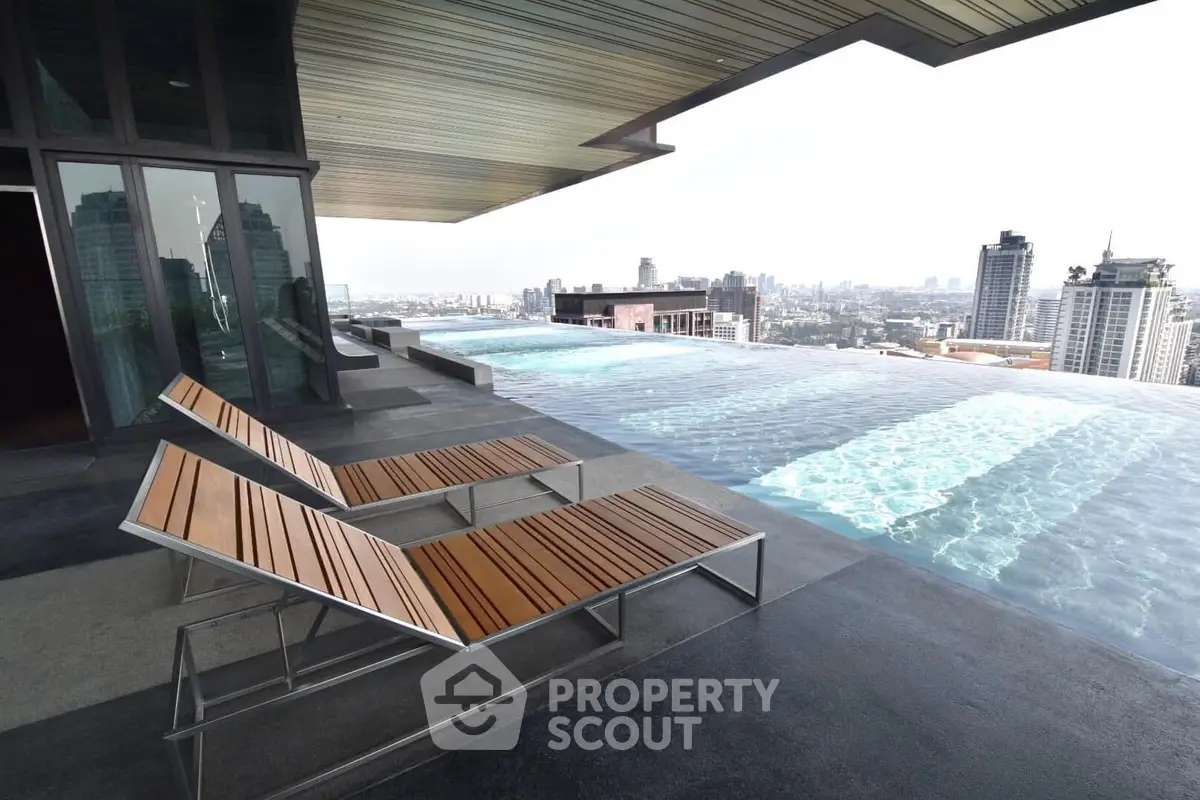 Luxurious rooftop infinity pool with stunning city skyline views and modern lounge chairs.